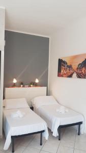 Habitación con 2 camas y una pintura en la pared. en BNBOOK - Green Zone Studio, en Paderno Dugnano