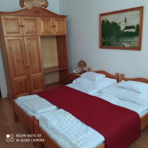 A bed or beds in a room at Bacchus Panzió