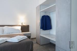 a bedroom with a bed and a blue jacket on a closet at Du Lac Aparments in Desenzano del Garda