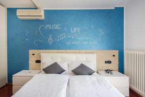 1 dormitorio con 1 cama con notas musicales en la pared en Music & Bike, with garden and veranda + Bicycles, en Arco