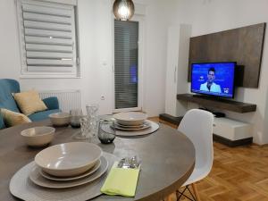 a dining room with a table and a tv at Carmen deluxe in Novi Sad