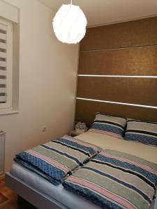 een slaapkamer met een bed met een bruin hoofdeinde bij Carmen deluxe in Novi Sad +21 foto's