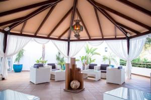 
a living room filled with furniture and umbrellas at Hotel Princesa Playa in Son Xoriguer
