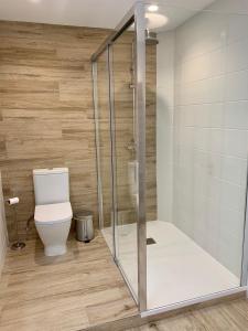 a bathroom with a toilet and a glass shower at Casa Carla in Arrecife +12 photos