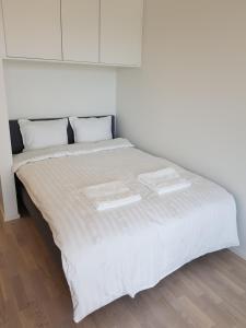 a white bed with two trays on top of it at New studio in West-Pasila in Helsinki