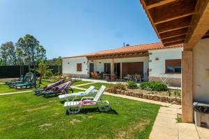 a group of lawn chairs sitting in a yard at Montes de Praias GuestHouse in Aljezur