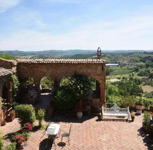 a brick building with a bench on a patio at Osteria Del Vicario in Certaldo