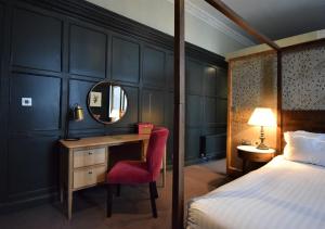 a bedroom with a bed and a desk and a mirror at The Globe in Warwick