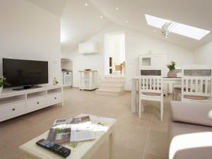 un salon blanc avec une télévision et une table dans l'établissement Luxury villa Lovely maiden near Vela Luka, pool, à Vela Luka