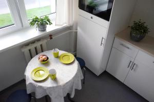 Una pequeña mesa en una cocina con platos amarillos. en Apartment City Heart, en Valmiera