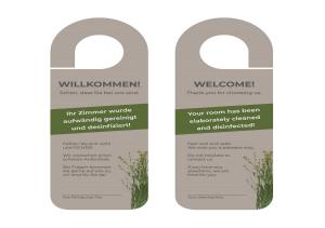 twee etiketten voor een deur met een bos gras bij Hotel AI Königshof in Berlijn