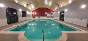 a swimming pool with blue water in a building at LLety Cynin in Llangynin