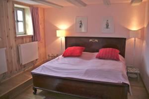 a bedroom with a large bed with two red pillows at Brezelhaus in Tangermünde