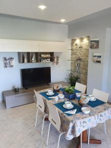 NEW PANORAMA في ريبوستو: غرفة طعام مع طاولة مع كراسي وتلفزيون