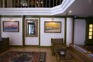 イスタンブールにあるイスタンブル ロイヤル ホテルの壁画と椅子が備わる待合室