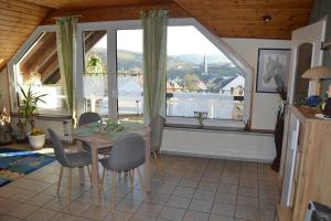 een eetkamer met een tafel en stoelen en een raam bij Ferienwohnung Auszeit Waxweiler in Waxweiler