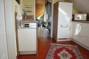 a kitchen with a white refrigerator and a red tile floor at Ferienwohnung Auszeit Waxweiler in Waxweiler