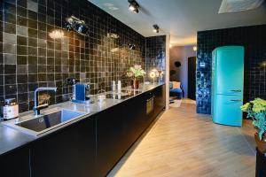 a kitchen with a sink and a blue refrigerator at Cora Apartments in Leipzig