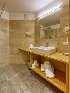 bagno con lavandino e specchio di Hotel Rose a Villabassa
