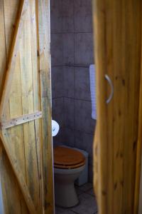 a bathroom with a toilet with a wooden door at iLanga Lodge in St Lucia