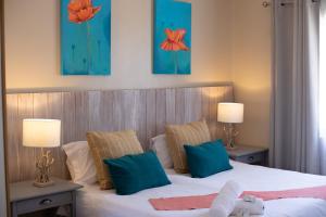 a bedroom with a bed with blue and orange pillows at iLanga Lodge in St Lucia