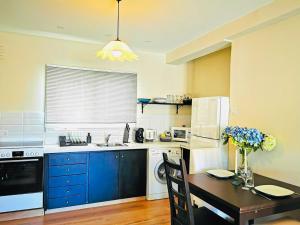 a kitchen with blue cabinets and a table and a refrigerator at Kareem flat in Larnaca