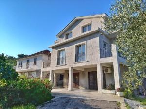 Un gran edificio blanco con balcones en una calle. en Petivat Gardens, en Tivat