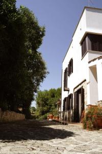 Ein weißes Gebäude mit einem Baum daneben. in der Unterkunft Casa Marisa Villa Vacanza in Castellana Grotte