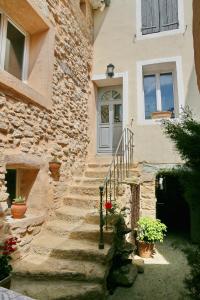 a stone house with stairs leading up to a door at Le Bastidon de Louis, L'Isle sur la Sorgue in LʼIsle-sur-la-Sorgue