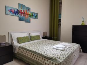 1 dormitorio con 1 cama con toallas en Casa Messina Inn, en Messina
