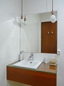 een badkamer met een wastafel en een spiegel bij Home for Travellers ll in Ponta Delgada