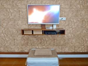 a living room with a television on a wall at Home for Travellers ll in Ponta Delgada