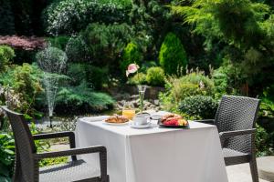 a white table with a plate of food on it at Booking Hotel & Spa in Krakow