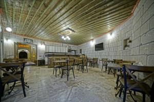a restaurant with tables and chairs in a room at Cappadocia Fairy Tale Suites in Göreme