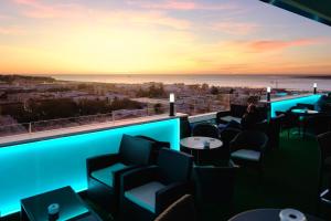 a restaurant with a view of the city at sunset at Hotel Guadalquivir in Sanlúcar de Barrameda