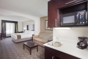 Habitación de hotel con cama y cocina en Holiday Inn Express Hotel & Suites Mebane, an IHG Hotel, en Mebane