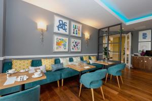 a restaurant with two tables and blue chairs at Oakley Hall Hotel in Basingstoke