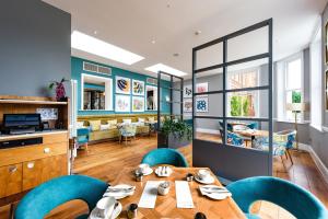 a dining room with a table and blue chairs at Oakley Hall Hotel in Basingstoke