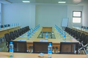 uma sala de conferências com uma mesa longa com garrafas de água em Asmara Hotel em Lusaka