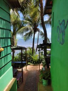 uma vista para um pátio com palmeiras e para o oceano em Hostel Casa de Jack em Pipa