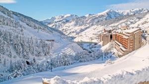 un complejo en las montañas cubierto de nieve en Sport Hotel Village, en Soldeu