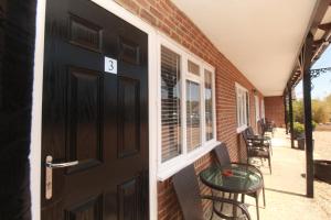 a black door with a table next to a brick building at Kings Head Inn in Rye