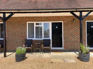 a brick house with a table and chairs in front of a door at Kings Head Inn in Rye