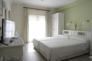 Un dormitorio con una gran cama blanca y una ventana en TRH Mijas, en Mijas