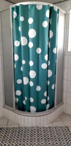 La salle de bains est pourvue d'un rideau de douche avec des points de polka blancs. dans l'établissement Private Logies Texel Woodart, à Midden-Eierland