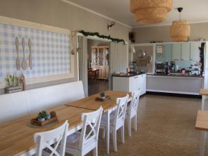 a kitchen and a dining room with a table and chairs at Skålleruds Gård in Åsensbruk