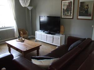 un soggiorno con divano e TV a schermo piatto di Skålleruds Gård ad Åsensbruk
