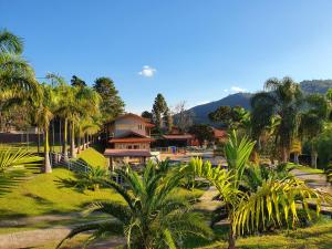 a resort with palm trees and a building at Pousada Nefelibatas in Águas de Lindoia