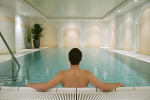 mężczyzna siedzący w basenie w obiekcie Hotel & Restaurant Sonne w mieście Rudersberg