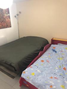 een slaapkamer met een bed met een blauw dekbed bij Logement cosy proche Paris et Disneyland in Villiers-sur-Marne